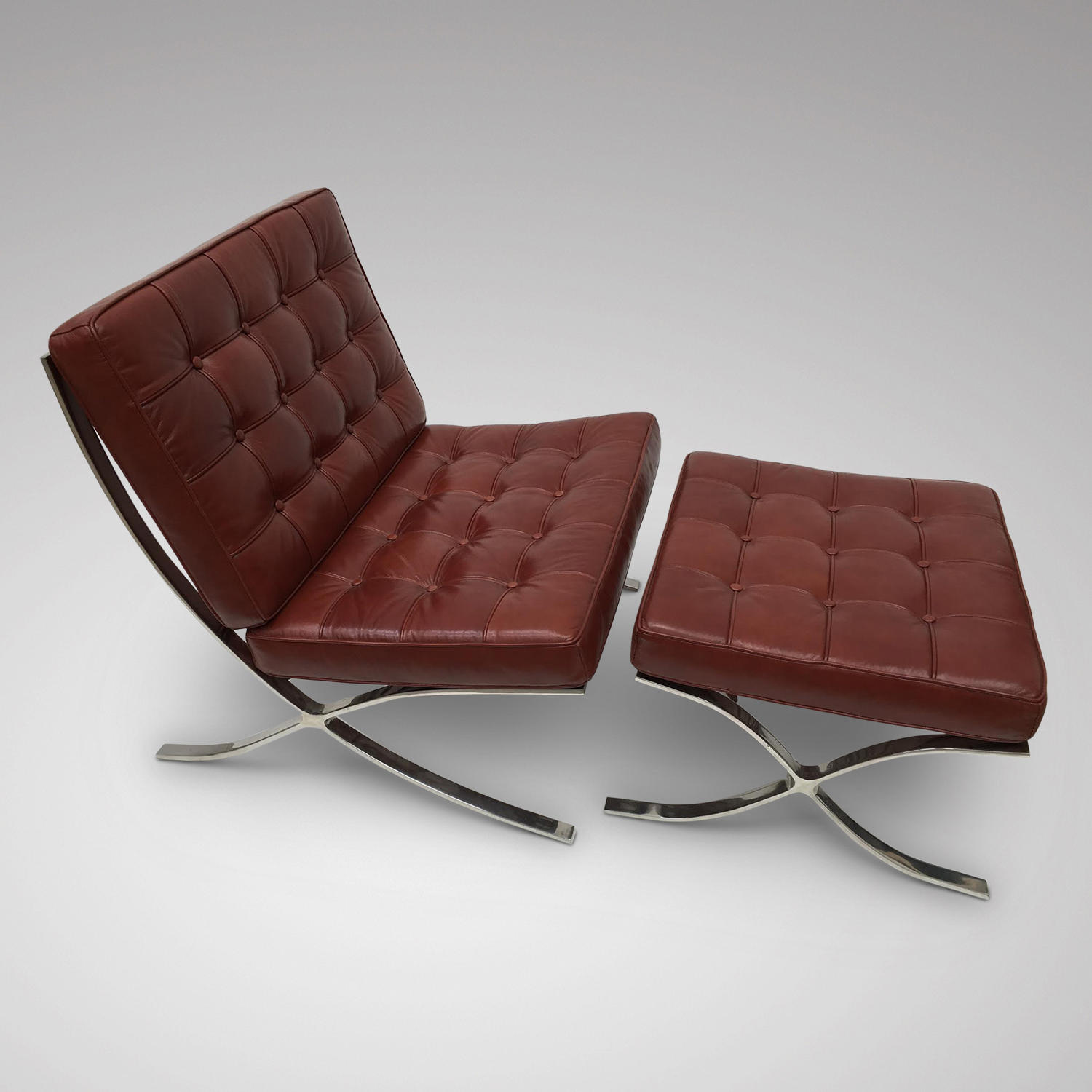 A MODERN LEATHER UPHOLSTERED CHAIR WITH MATCHING FOOTSTOOL